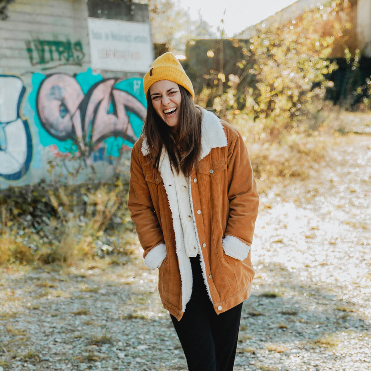 Herbstsonne-lachende-Frau-vor-Graffitti